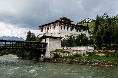 Gazebo by river against sky