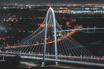 Illuminated suspension bridge in city at night