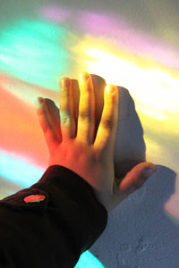 Close-up of hands against multi colored sunset