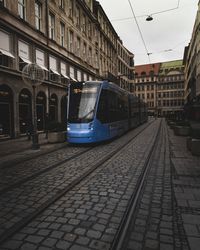 Railroad tracks amidst buildings in city