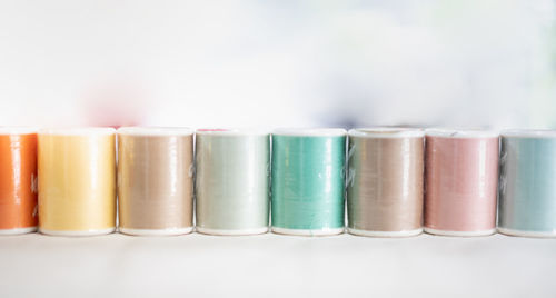 The pastel color embroidery thread spool using in the garment industry, a row of multicolored yarn.