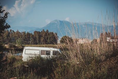 Van parked on grassy field against sky