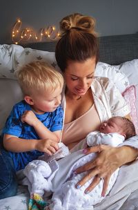 High angle view of mother with children on bed at home