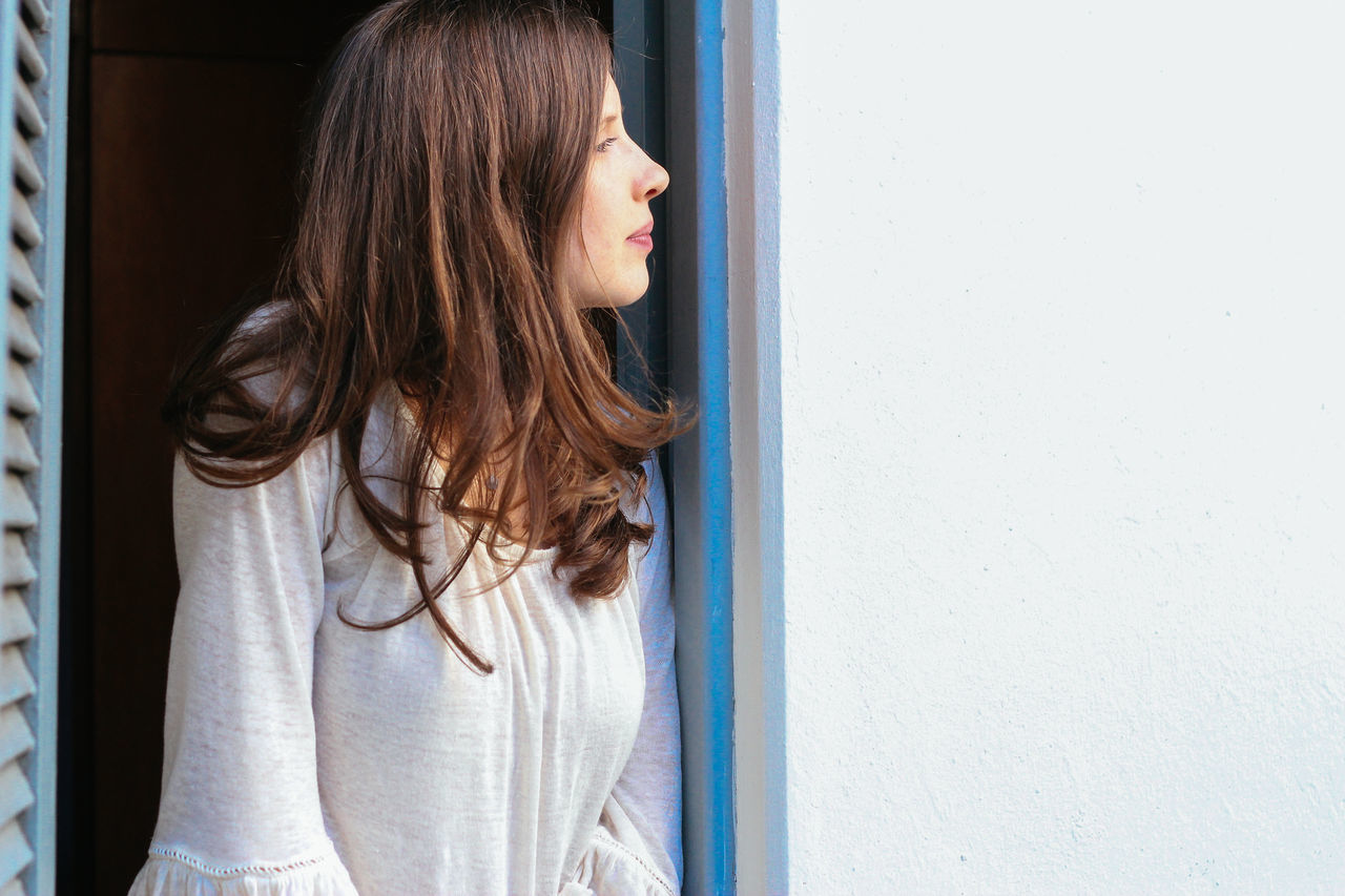 YOUNG WOMAN STANDING ON FLOOR