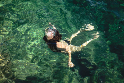 High angle view of young woman swimming in sea