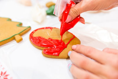 Close-up of hand holding red chili peppers on table