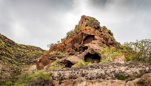 Low angle view of rock formation on land against sky