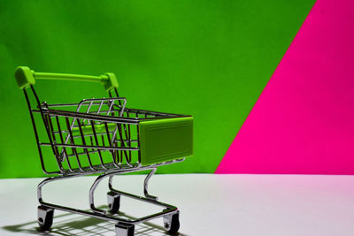 Close-up of empty chairs against pink wall