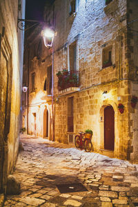 Street amidst buildings in city at night