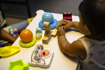 High angle view of boy playing with toys on table