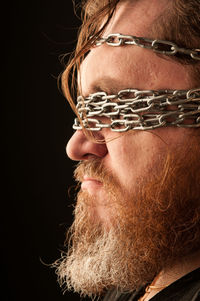 Portrait of man wearing mask against black background