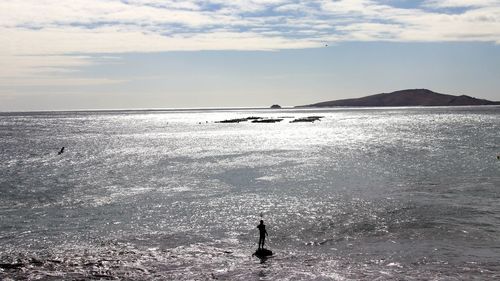 Silhouette man on beach against sky