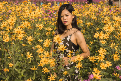 Portrait of woman by yellow blooming flowers