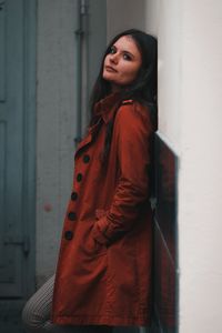 Portrait of woman standing against wall