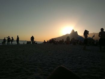 People at beach during sunset