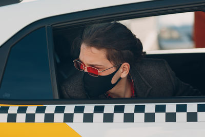 Portrait of woman sitting in car window