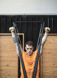 Sportsman doing suspension training exercise in gym