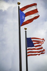 Low angle view of flag flags against sky