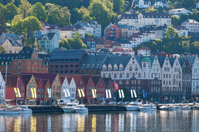 Sailboats in river by buildings in city