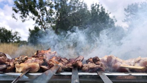 Panoramic shot of cooking on barbecue grill against sky