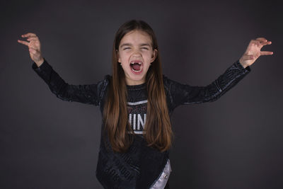 Portrait of happy girl against gray background