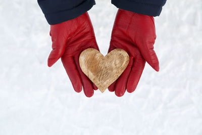 Low section of woman holding heart shape in winter