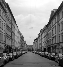 Cars on street in city against sky