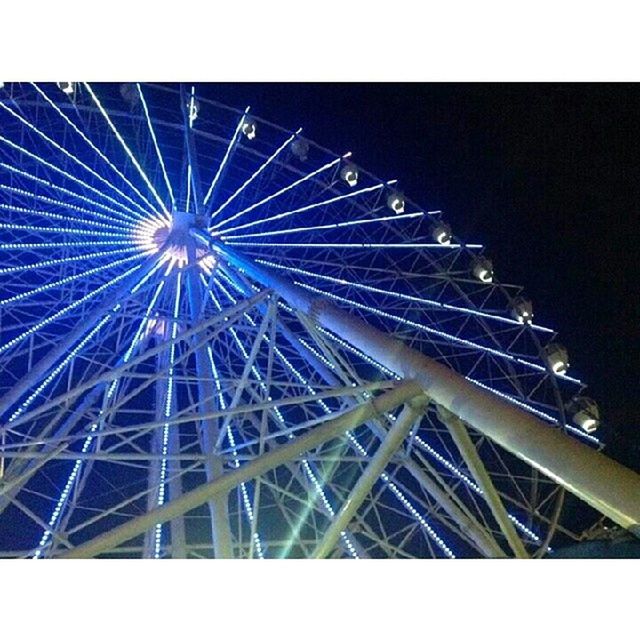 low angle view, built structure, architecture, night, transfer print, illuminated, clear sky, auto post production filter, arts culture and entertainment, sky, connection, ferris wheel, copy space, metal, bridge - man made structure, outdoors, no people, engineering, amusement park ride, amusement park