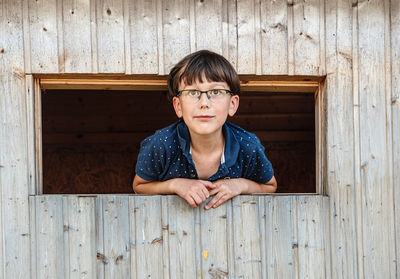 Portrait of a smiling boy looking through the window