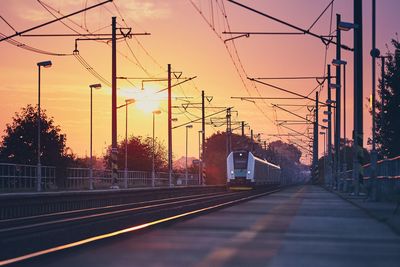 Railroad tracks against sky during sunset