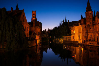 Brugge at night, reflections of ancient buildings in water, canal 