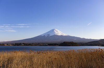 Scenic view of snowcapped mountains by lake against sky