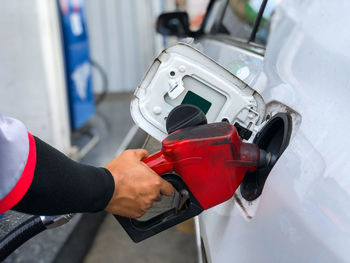 Midsection of man holding camera at car