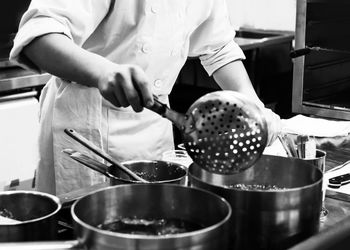 Midsection of man preparing food in kitchen at home