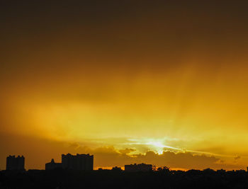 Silhouette buildings against sky during sunset