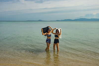 Female friends standing at beach