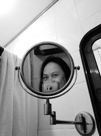 Close-up portrait of woman with reflection on mirror