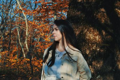 Young woman looking away in forest