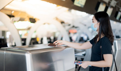 Side view of young woman standing at airport