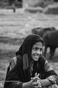 Portrait of smiling young woman sitting outdoors