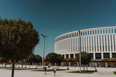 Street by building against clear blue sky