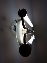 Close-up of illuminated lamp against wall