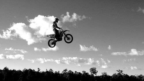 Low angle view of motocross rider performing stunt in mid-air
