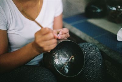 Midsection of woman carving container