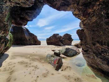 Rocks on beach against sky