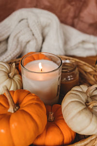 Cozy fall still life composition with decorative pumpkins and burning candle. autumn home decor