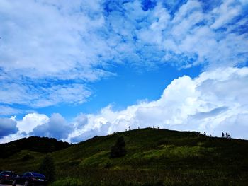 Low angle view of landscape against blue sky