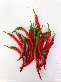 High angle view of red chili peppers against white background