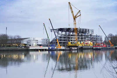 Sailboats in harbor against sky