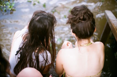 Two young friends sitting by the river.